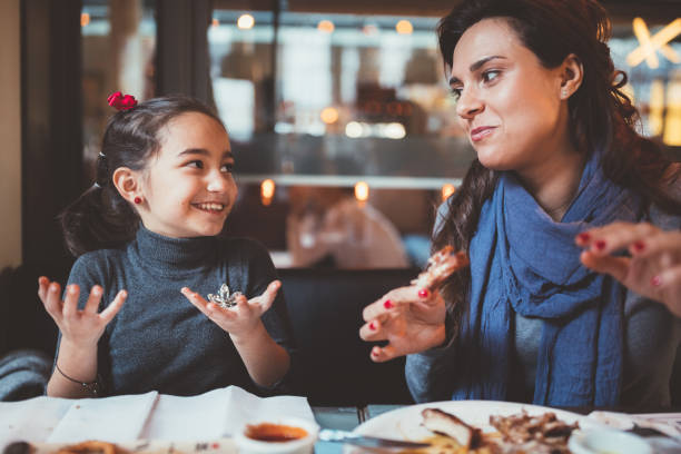 istock Mother and daughter over eating in expensive restaurant 1038963244