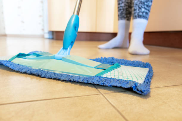 istock Cropped image of beautiful young woman using a blue mop while cleaning the floor in kitchen 1038965314
