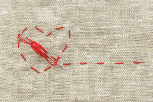 istock sewing thread and for knitting, a red string in the form of a medical heart on instruments 1038965724