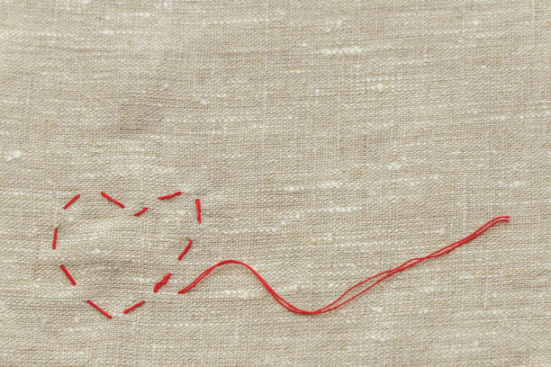 istock sewing thread and for knitting, a red string in the form of a medical heart on instruments 1038965732