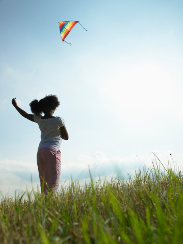 happy little girl on his father shoulder with colorful kite