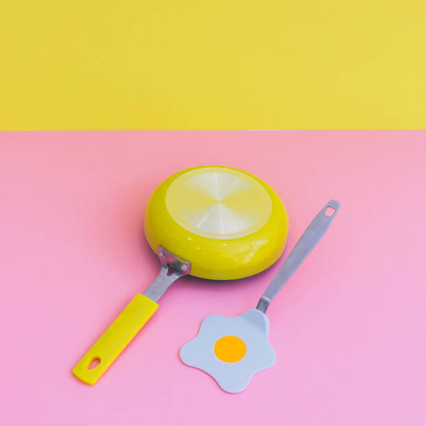 istock fried eggs and yellow frying pan double background. 1038970528