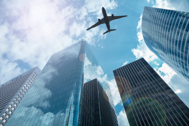 Airplane in the sky with modern buildings, with a blue sky stock photo
