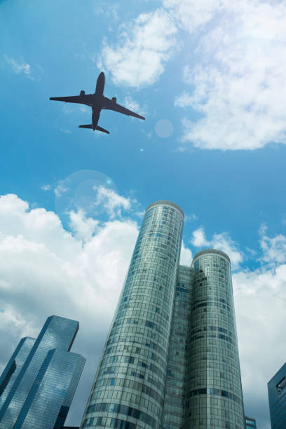 istock Airplane in the sky with modern buildings, with a blue sky 1038973528