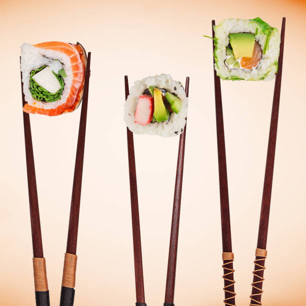 istock Traditional japanese sushi pieces placed between chopsticks, separated on pastel background. 1038981820