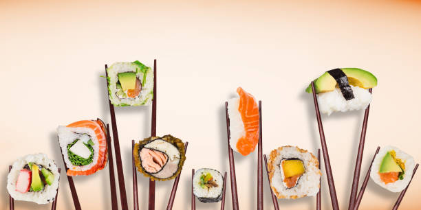 istock Traditional japanese sushi pieces placed between chopsticks, separated on pastel background. 1038986990