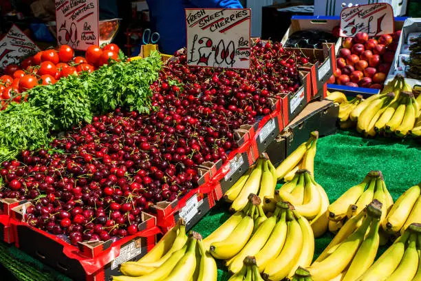 Photo of Cherries, bananas and other fruit stand in open air market