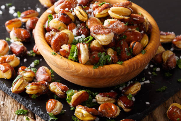 istock Delicious appetizer fried salted broad beans with greens in a bowl close-up. horizontal 1039002048