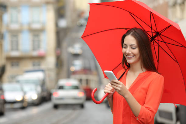 istock Woman using a smart phone under the rain 1039003906