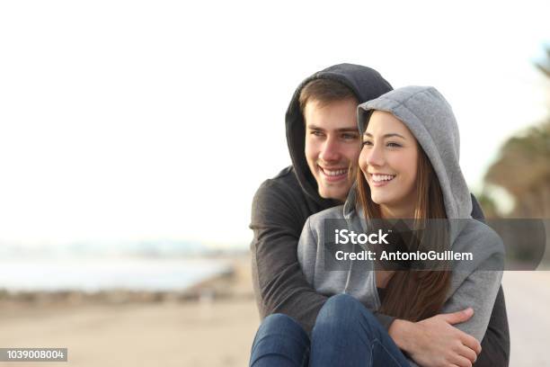 Couple Of Teens Looking At Horizon On The Beach Stock Photo - Download Image Now - Teenager, Couple - Relationship, Adolescence