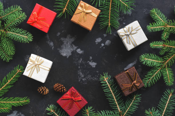 istock Multi-colored gift boxes and spruce branches on a dark background. Christmas background, top view. Flat lay,copy space 1039018214