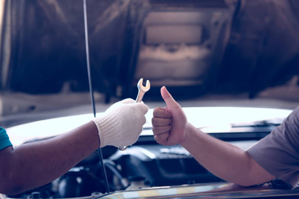 istock Automotive mechanical hand holding spanner tool for fixing with customer hand raised thumb up, car maintenance service concept. 1039020862