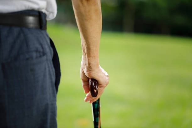 Senior woman holding bag for golf. Close up. Focus is on hands.