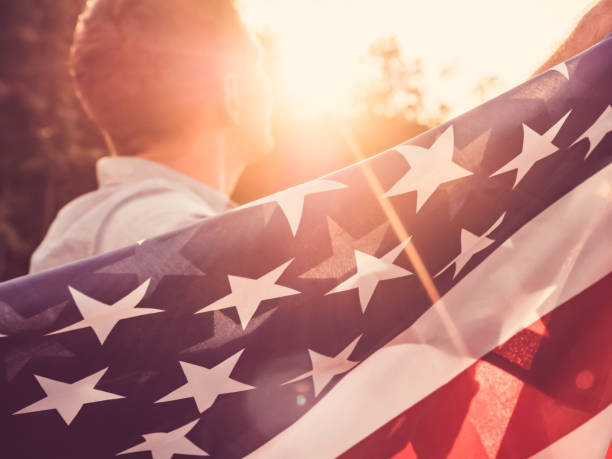 istock Attractive man holding waving in the wind US flag 1039048262