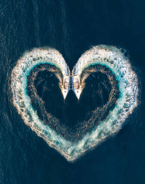 due barche formano la forma di un cuore sulla superficie dell'oceano - recreational boat motorboat speedboat aerial view foto e immagini stock