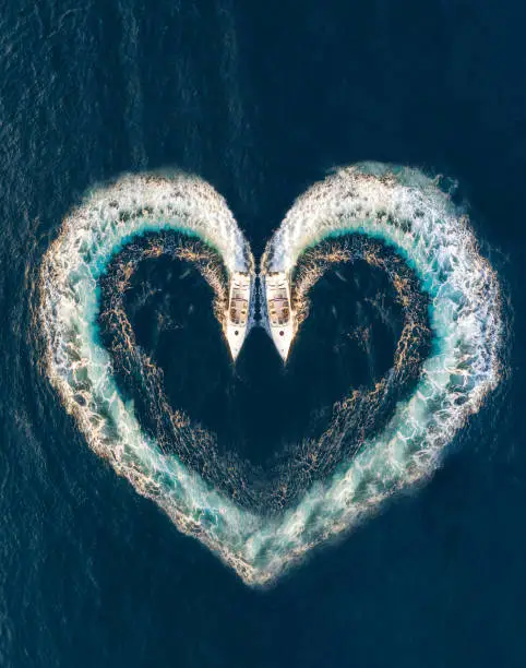 Photo of Two boats form a shape of a heart on the ocean surface