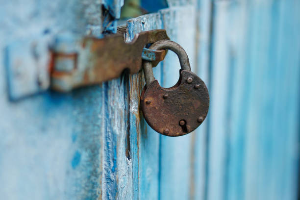 Old rusty padlock that closes the blue door. Creative art background. Stock Photo stock photo