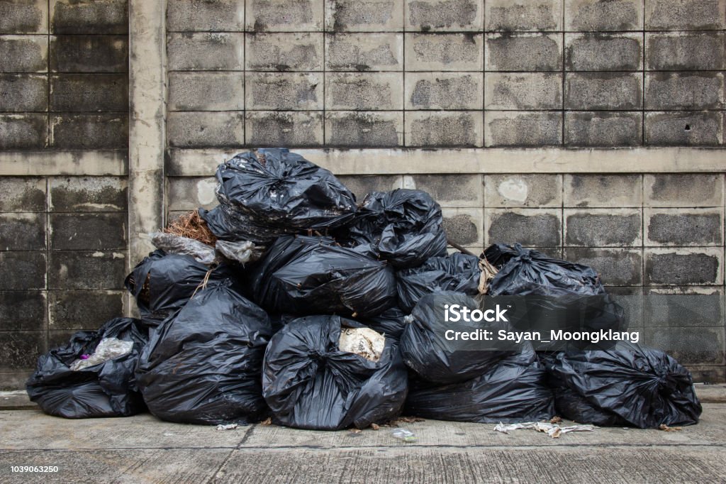 Bag trash on street or sidewalk with old brick wall. Bag trash on street or sidewalk with old brick wall for background. Garbage Stock Photo