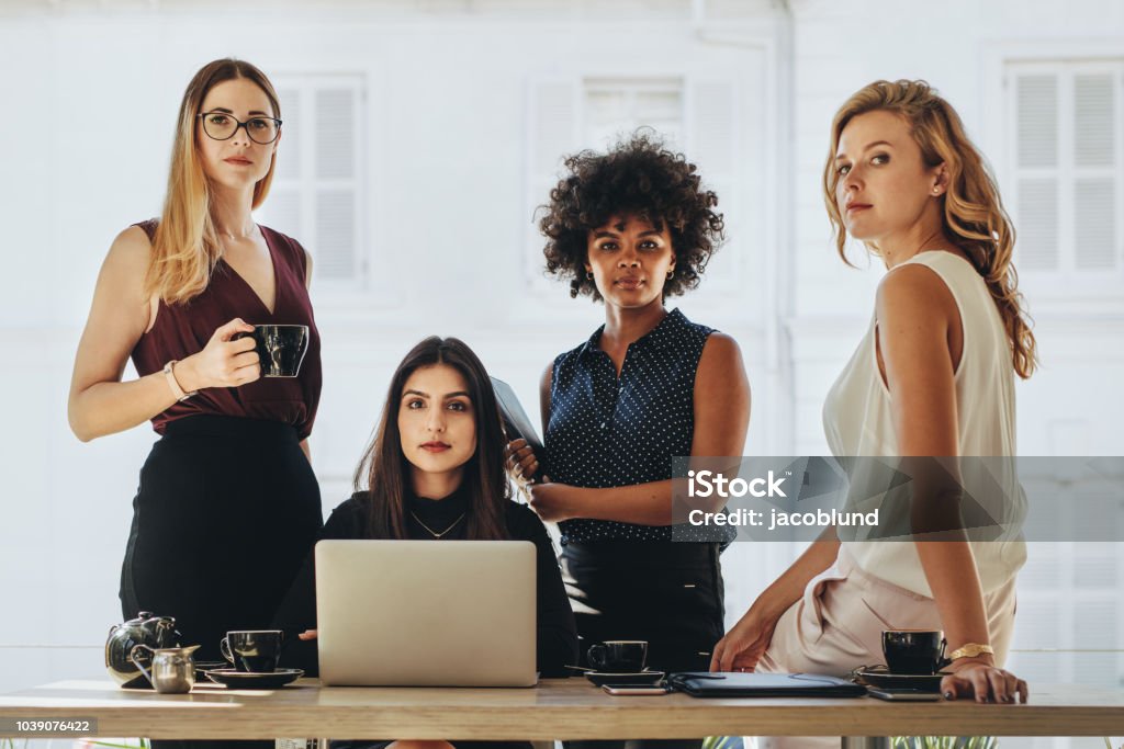 Female startup business team Group of multiracial businesswomen in casuals together at office desk and looking at camera. Female startup business team portrait. Women Stock Photo