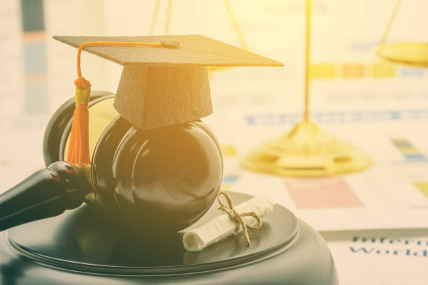 istock Graduate study abroad program concept : Graduation cap on a gavel, balance scale of justice behind, a certificate. Graduate study abroad program is a program that accept students from foreign country 1039076574