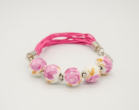 Pink beaded bracelet on white background close up