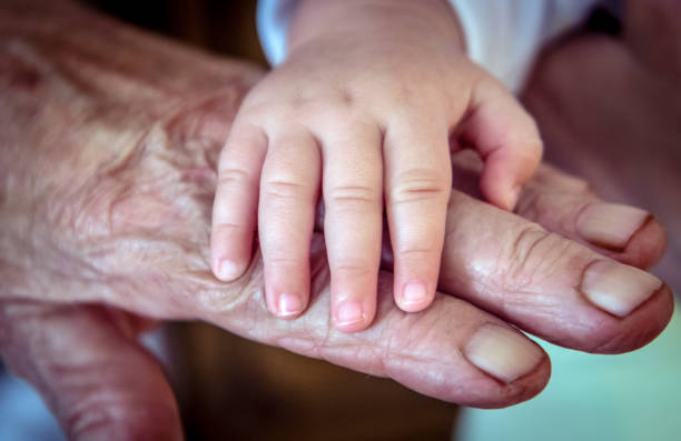 istock Baby's And Old Rough Grandma's Hand 1039079446