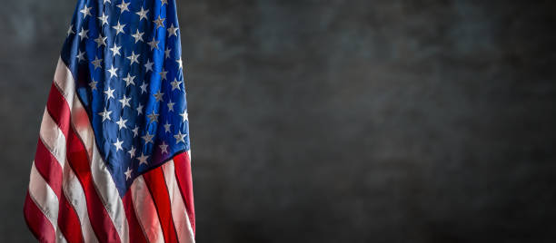 istock American flag freely hanging against a dark wall. 1039079524