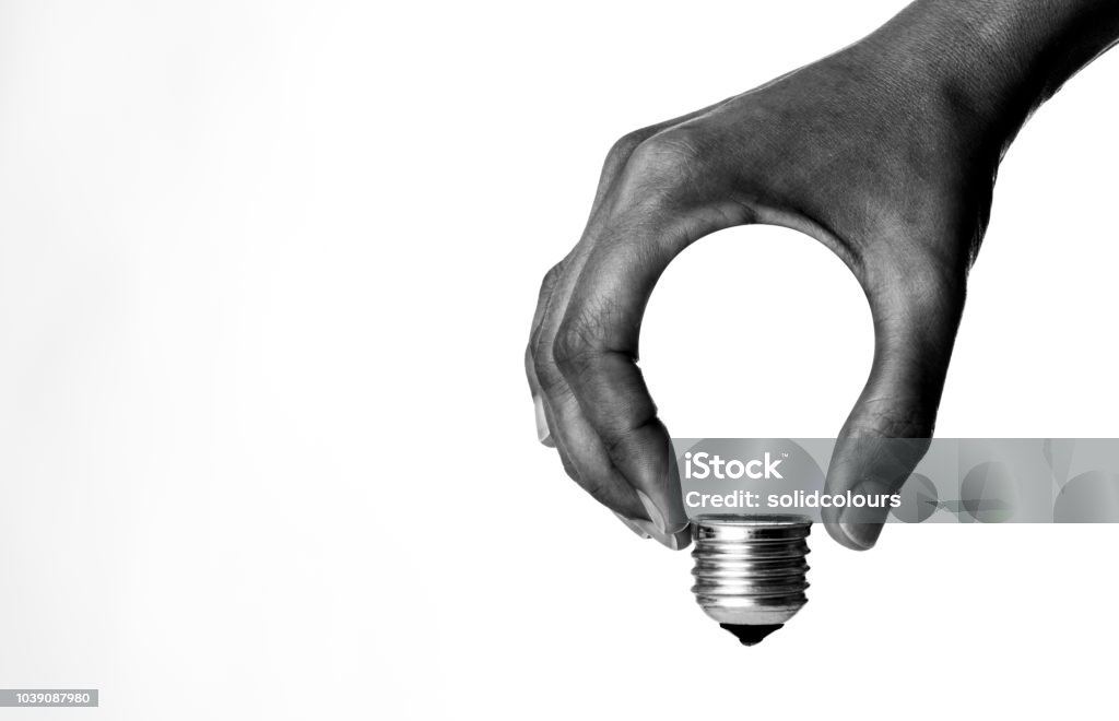 Light Bulb in Hand Light bulb in human hand, b&w. Innovation Stock Photo