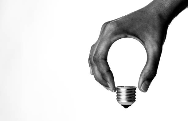 Light Bulb in Hand Light bulb in human hand, b&w. concepts and ideas stock pictures, royalty-free photos & images