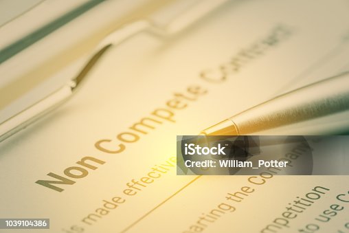 istock Legal form concept : Blue pen and a non compete contract on a clipboard. Noncompete contract is an agreement between employee and employer, not to enter into competition in subsequence business effort 1039104386
