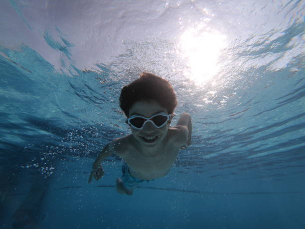 istock Boy swimming underwater in swimming pool 1039112088