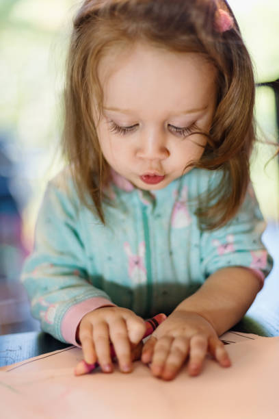 istock Girl Plays with Colouring Book 1039112578