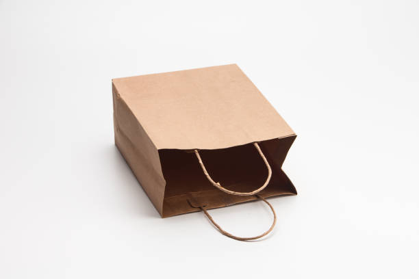 istock Empty open brown craft paper shopping bag lying on white 1039132770