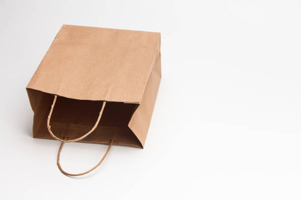 istock Empty open brown craft paper shopping bag lying on white 1039132802