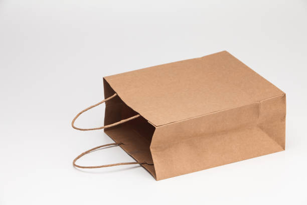 istock Empty open brown craft paper shopping bag lying on white 1039132814