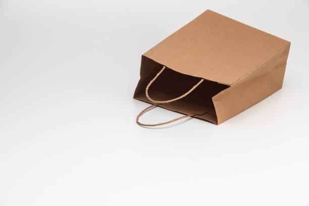 istock Empty open brown craft paper shopping bag lying on white 1039132834