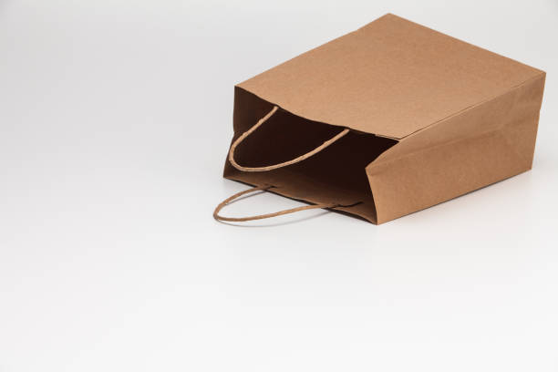 istock Empty open brown craft paper shopping bag lying on white 1039132840