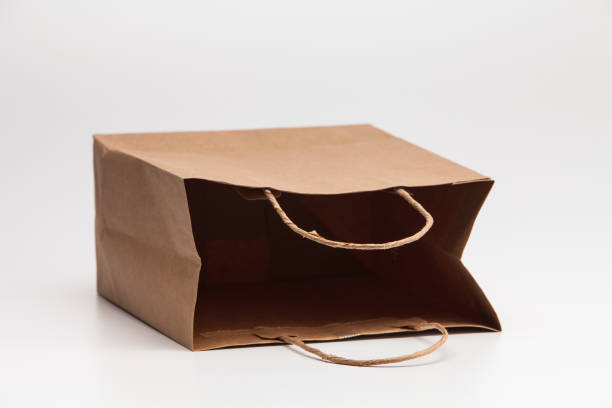 istock Empty open brown craft paper shopping bag lying on white 1039132878