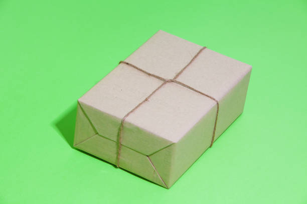 istock Brown eco kraft gift wrapped box on strong green background 1039141874