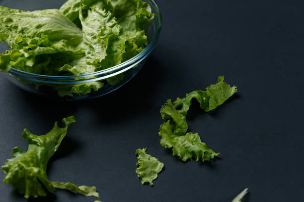 istock fresh salad leaves in bowl on dark background. Top view 1039162848