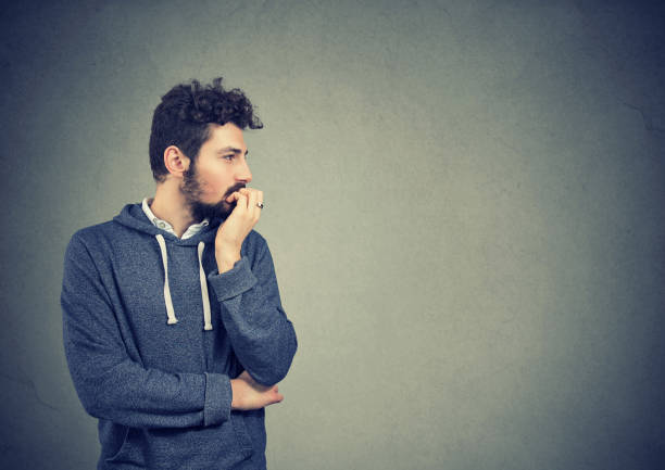 hombre ansioso preocupado morder sus uñas - nail biting guilt men anxiety fotografías e imágenes de stock