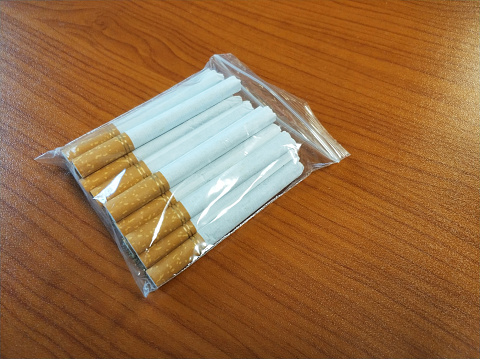 Transparent package of cigarettes on wood table