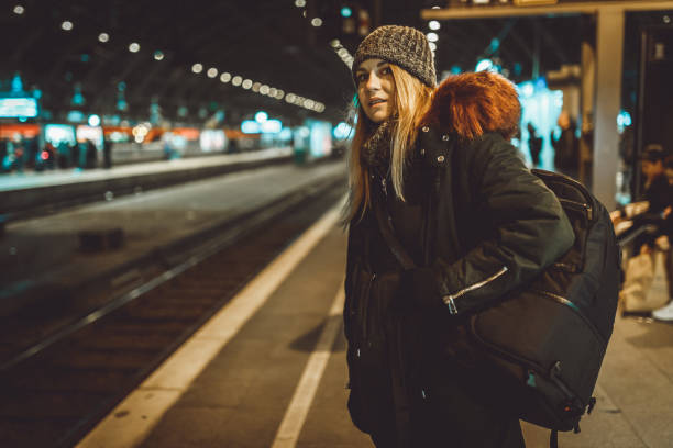 istock Woman with a backpack waiting for a train at the train station 1039202324