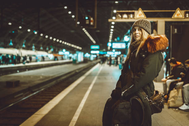 istock Woman with a backpack waiting for a train at the train station 1039202328