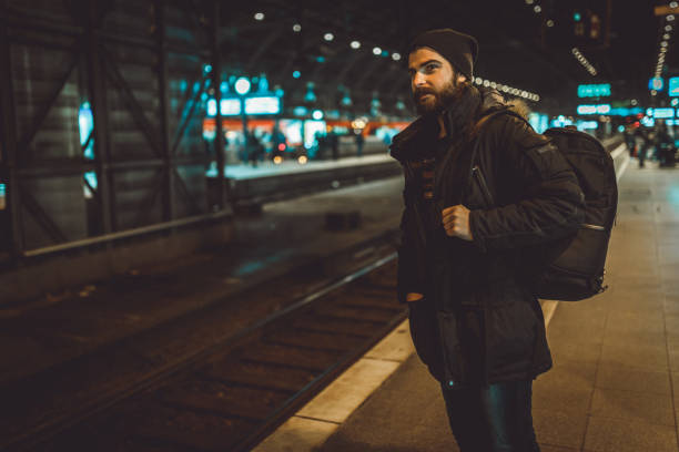 istock Young tourist with a backpack waiting for a train at the train station 1039210012
