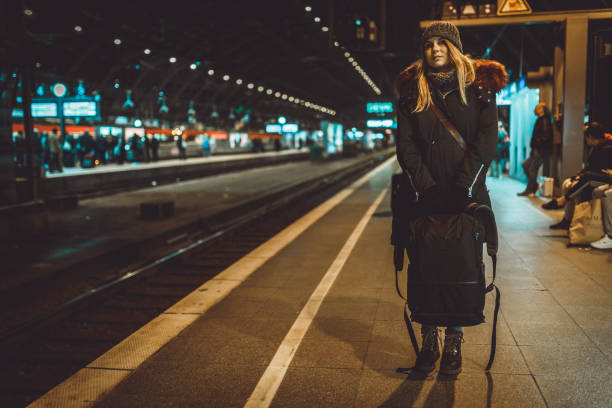 istock Woman with a backpack waiting for a train at the train station 1039210110