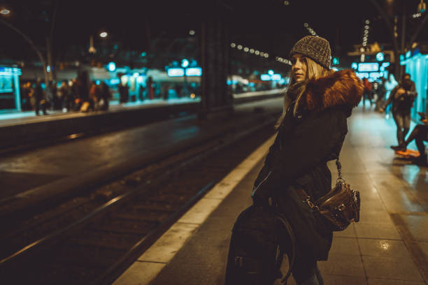 istock Woman with a backpack waiting for a train at the train station 1039210120