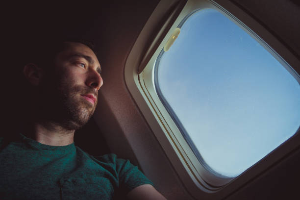 istock Pensive man looking outside through the window of an airplane 1039214596