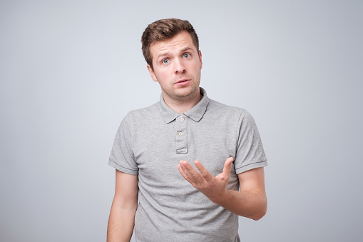 Young caucasian man half-length portrait isolated on white studio background. He is defending his point of view or explaining his opinion