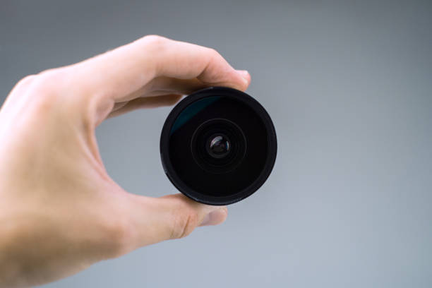 Old lens in hands on a white background